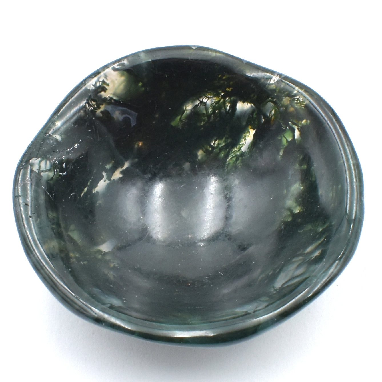 Deep green moss agate carved into a small polished bowl. stunning formations within and a wavy lining. top view.