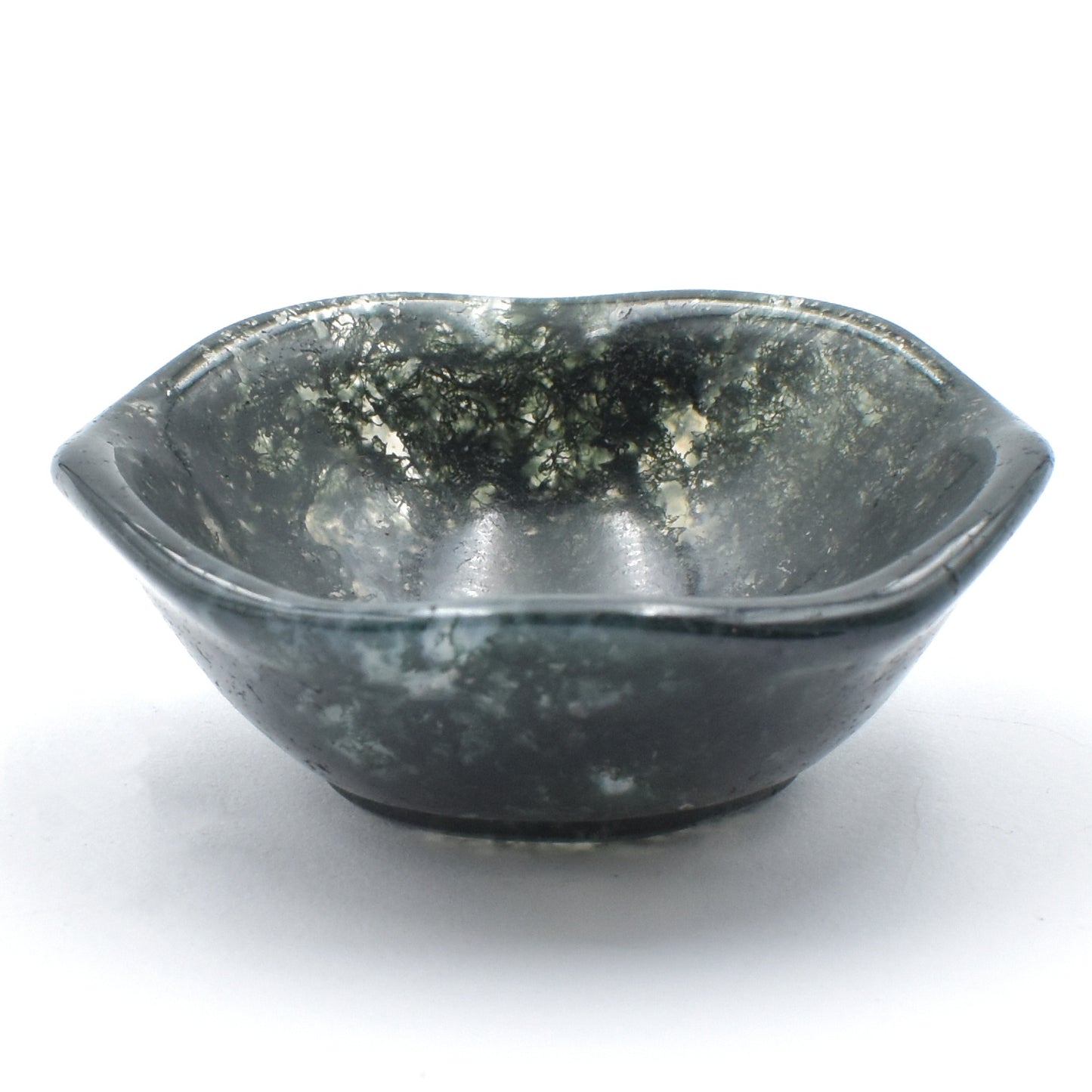 Deep green moss agate carved into a small polished bowl. stunning formations within and a wavy lining. side view